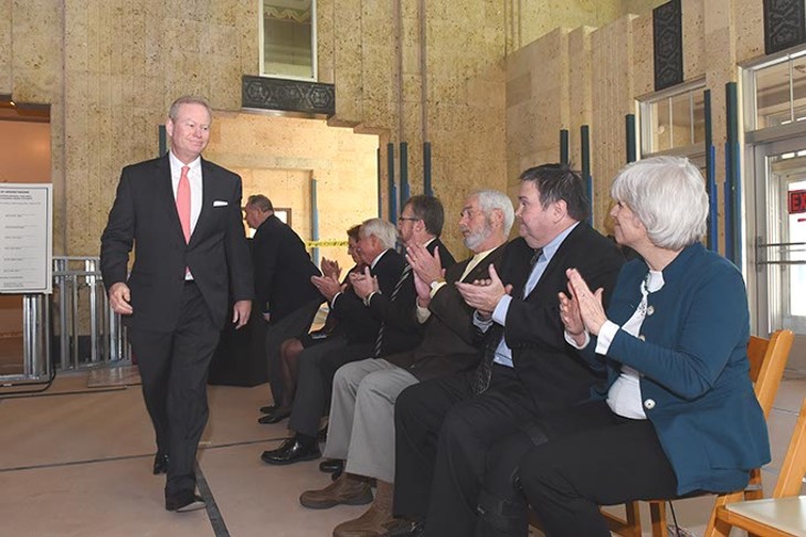 Oklahoma City Mayor Mick Cornett walks to his seat after speaking while five other mayors of the metro area and other officials applaud, during a signing ceremony held in the historic Santa Fe Station, being designated the regioal transit hub, in downtown OKC, 12-1-2015. - MARK HANCOCK