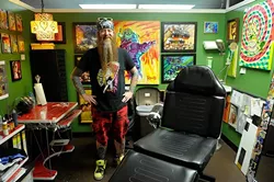 Rawb Carter poses for a photo at his booth at Mind Bender Tattoo Shop in Oklahoma City, Wednesday, July 22, 2015. - GARETT FISBECK