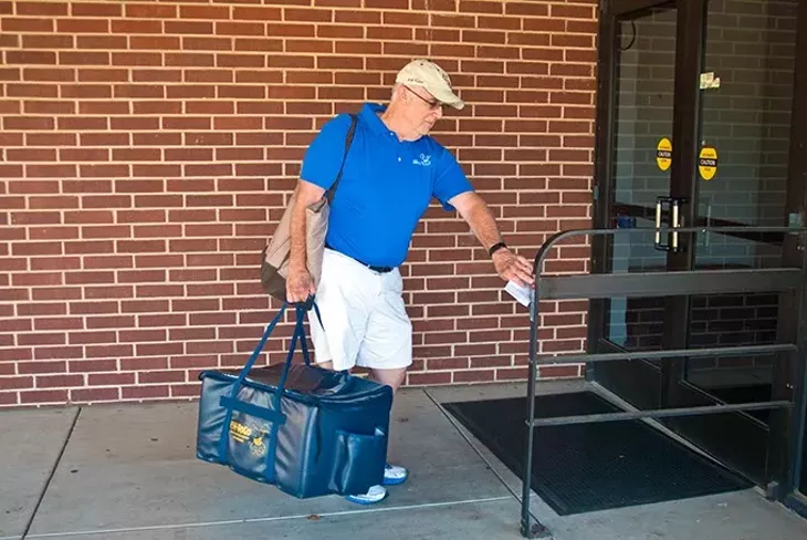 Gary Colvin with 858-ToGo, makes a lunchtime food delevery to a local medical office building recently. mh