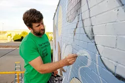 Scott Henderson works on a mural outside Antique Avenue in Oklahoma City, Monday, Oct. 26, 2015. - GARETT FISBECK