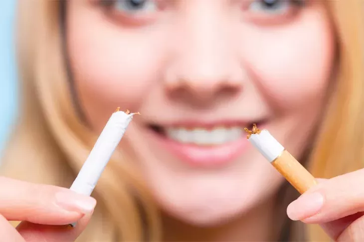 Addiction. Closeup of young woman determined girl breaking the cigarette. Quit smoking. Studio shot. - ** Note: Shallow depth of field - BIGSTOCK