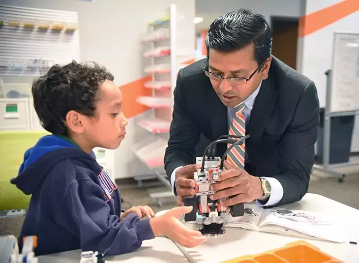 Ray Shaik works with 5 year old, Avery Watson, with a robot project at techJOYnt, after school program in Edmond, 11-12-15. - MARK HANCOCK