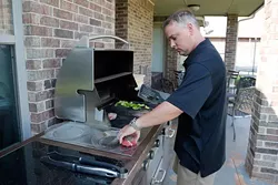 Billy Wilson, owner of Opus Prime Steakhouse, cooks steak at his home. (Garett Fisbeck)