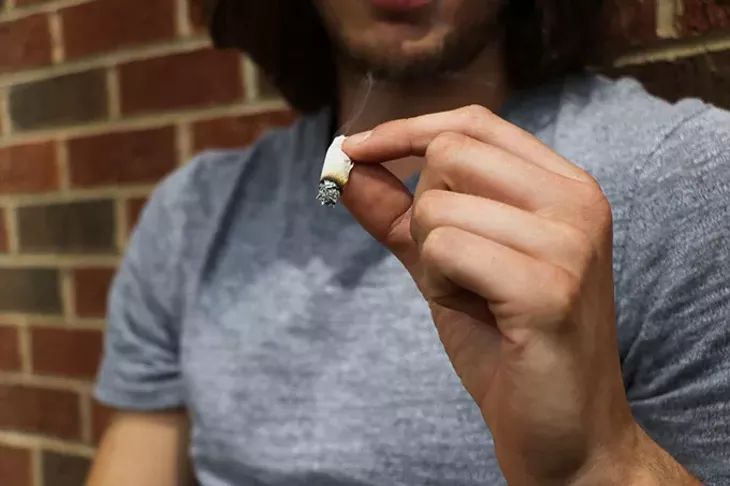 Student smokes (the one of the student smoking): A student smokes a joint. Students from states where recreational marijuana usage is legal sometimes face difficulties adjusting to life in a state like Oklahoma where pot is illegal. Lexie Patterson/The Daily