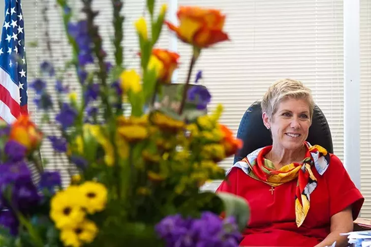 Janet Barresi, the outgoing State Superintendent of Public Instruction, discusses her term beyond a large, colorful arrangement of flowers, in her state office recently. mh