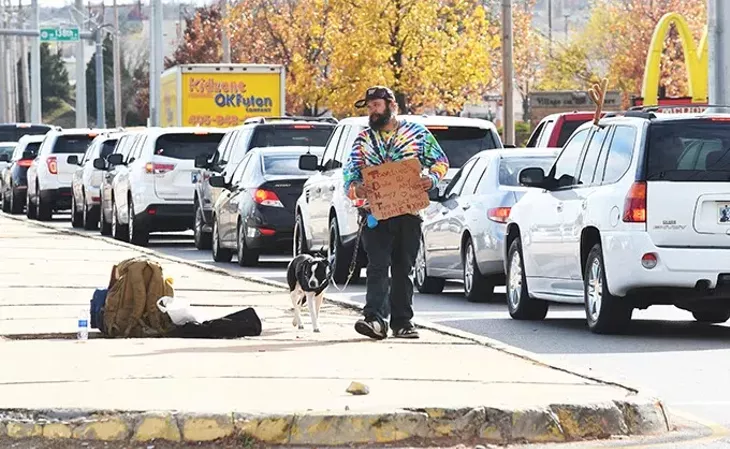A man and his dog panhandles from the median at NW 140th and Pennsylvania Avenue in Oklahoma City, 12-8-15. - MARK HANCOCK