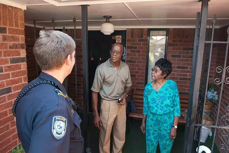 Midwest City Police Department Community Action Officer Roland "Rollie" Branham, speaks with with 86 year old Cora Rolison at her home next Randolph Grayson a neighbor who lives across the street, recently in MWC. mh