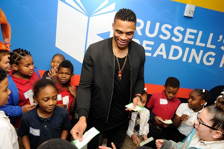 Russell Westbrook presents reading certificates to students during a book fair and opening of Russell's Reading Room at Edwards Elementary School in Oklahoma City, Tuesday, Jan. 5, 2016. - GARETT FISBECK