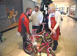 From left, Moore Oklahoma business owners, Greg Derr, and Michael Milligan bought gifts for ten children, including bicycles, and turned them over to Salvation Army volunteers, June McCoy and Terri Holcomb, at the Angel Tree in Penn Square Mall, 12-8-15. - MARK HANCOCK
