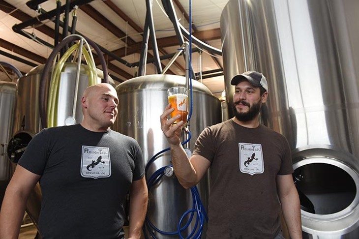 Left, Kevin Hall, director of LOCAL, and Tony Tielli, with Rough Tail Brewing Company, check out one of their draw beers in the light streaming between brewing vessels in their Midwest City production facility.  mh