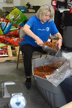 Mindy Duke seperates dog food into smaller bags at the Pet Food Pantry in Oklahoma City, Okla. - LAUREN HAMILTON