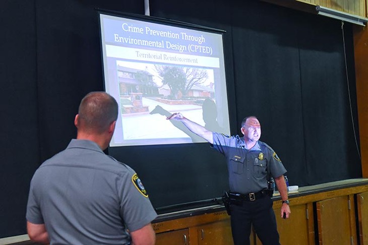Master Sargent Robert Skalla discusses an image of a residence during his Crime preventon Through Environmental Design presentation, with Master Sergeant Robert Henderson  watching, Thursday night in south OKC.  mh
