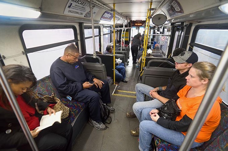 Passengers get comfortable near the rear of the Route 5 bus as it continues to board at the Embark downtown transite station, 3:30 pm, 11-20-15. - MARK HANCOCK