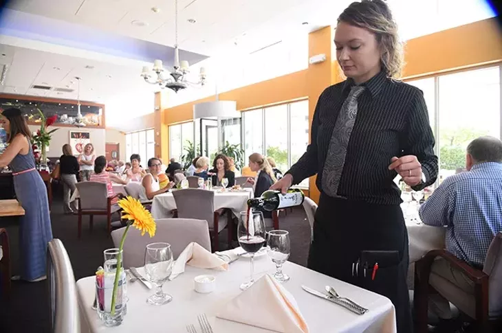 Waitress Elizabeth Wilson pours LA Capra Pinotage wine at the Museum Cafe recently. mh
