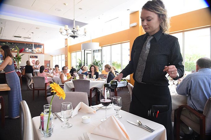 Waitress Elizabeth Wilson pours LA Capra Pinotage wine at the Museum Cafe recently.  mh