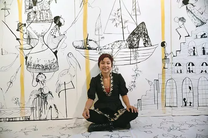 Artist Denise Duong with large, wall size artwork installation she created on panels usally researved for hanging works of art on, at JRB Art, 12-17-15. - MARK HANCOCK