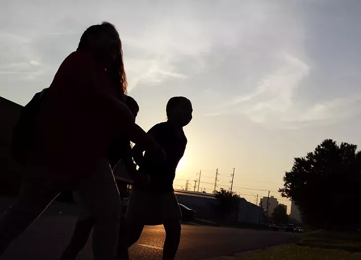 Students walk to the bus stop on the first day of class in the early morning hours on Aug. 4, 2014. - BEN FELDER