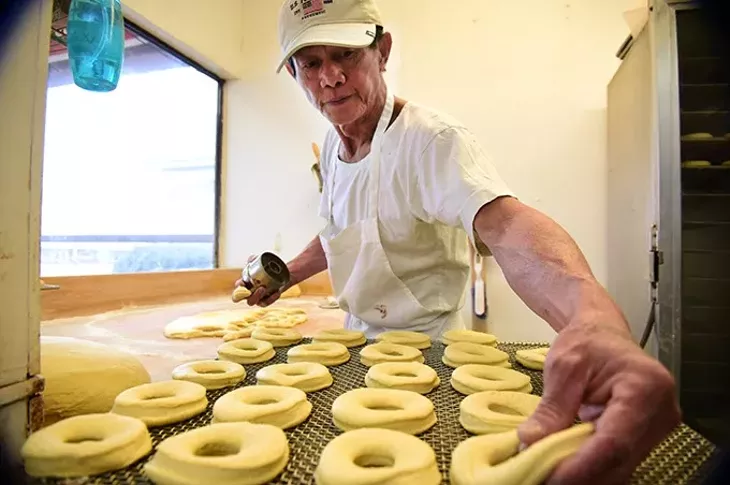 Sok San has been the baker at North May Donuts & Kolaches for over 5 years, shown forming donut dough on the recent busy Christmas Eve morning. mh