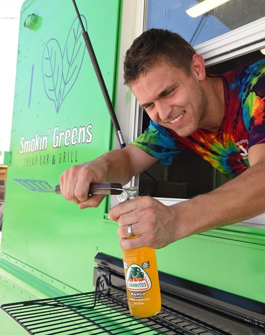 Levi Schmidt, owner of Smokin' Greens food truck, opens a Mango Jarritos for a customer, recently at Bleu Gartin.  mh