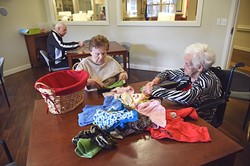 Residents at Prairie Winds Alzheimer's Special Care Center partake in daily rituals as part of Alzheimer's therapy such as folding clothes from laundry baskets and working puzzles.  mh