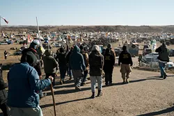 Hundreds of campers at North Dakota’s Standing Rock Indian Reservation participate in a prayer ceremony. Indigenous tribes from across North America show solidarity with Standing Rock Sioux Tribe’s struggle to protect its natural resources and sacred land. (Wade Dunstan / for Oklahoma Gazette)
