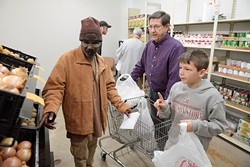 Elvis Howard shops for groceries with assistance from volunteers Les Wright and his grandson, Kaden Jacobs, 11, at Love Link Ministries.(Garett Fisbeck)