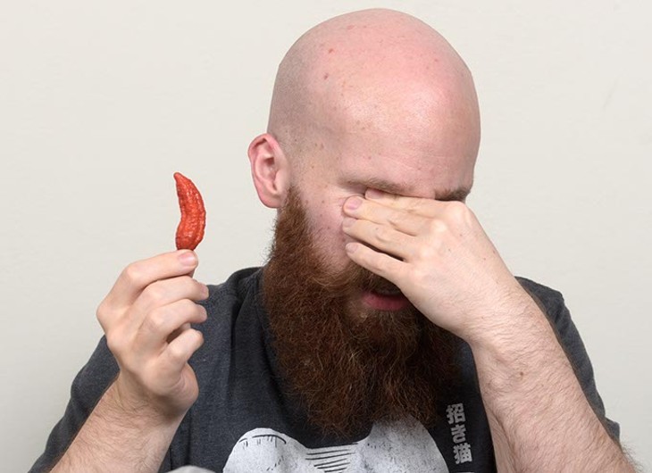 Matt Weems braces himself before eating another bhut jolokia ghost pepper. (Garett Fisbeck)
