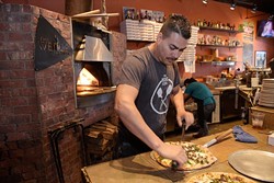 Jesus Cortez cuts a pizza at The Wedge, Monday, Oct. 24, 2016.  Cortez has worked at The Wedge for 8 years. - GARETT FISBECK