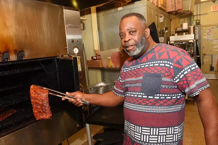 Marvin Preston pulls ribs out of the smoker at Dickey’s Barbecue Pit, a franchise he took over after nearly three decades out of the restaurant business.(Garett Fisbeck)