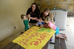 Lindsay Biggs and Rachael Robinson help children make an Earth Day banner at the Oklahoma City Zoo Wednesday, April 19, 2017. - GARETT FISBECK