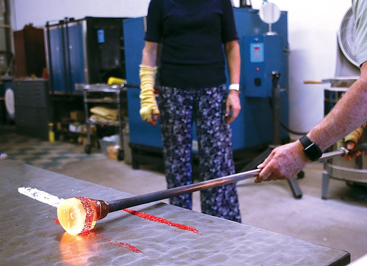 Lee Kessinger rolls colored glass pieces onto hot glass at G Gallery & Glass Studio in Guthrie. (Cara Johnson)