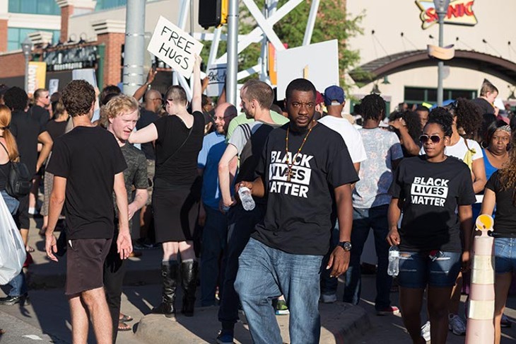 Protestors hold up signs at the Black Lives Matter protest on Sunday, July 10, 2016. - EMMY VERDIN