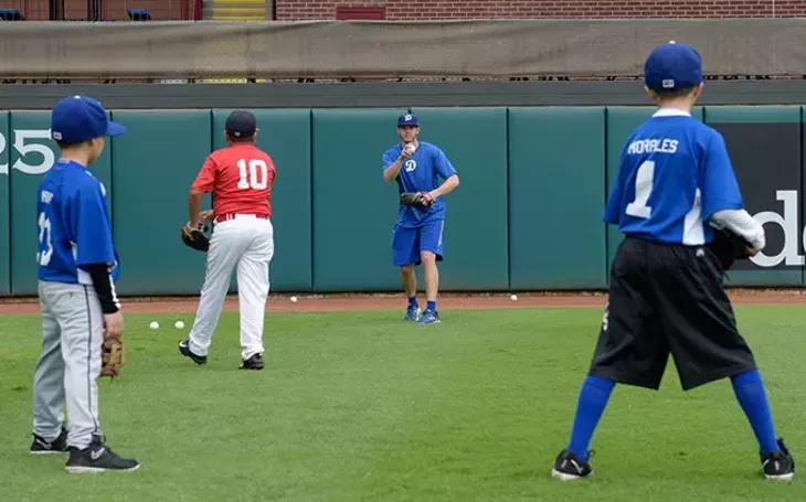 Scott Barlow works with children during an OKC Dodgers Clinic in conjunction with Supermercados Morelos, Friday, July 28, 2017. - GARETT FISBECK