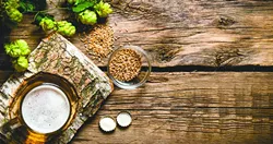 The beer style . Glass of beer on a birch stand malt and hops on wooden background. Top view - BIGSTOCK