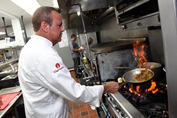 Meat Market Refectory co-owner and executive chef Steve Spitz sears off an entree in the kitchen. (Garett Fisbeck)