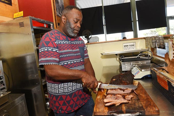 Marvin Preston slices brisket at Dickey's BBQ in Oklahoma City, Thursday, July 21, 2016. - GARETT FISBECK