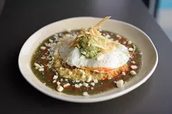 Chieftain's Revenge: spicy grits with tomatillo salsa, beer-braised pork, avocado salsa, fried eggs and Cotija cheese (Garett Fisbeck)