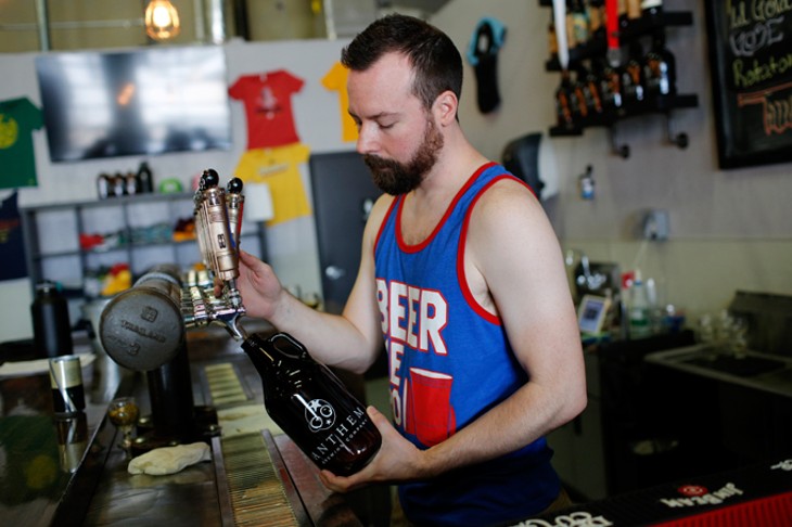 Ben Childers pours a growler of beer at Anthem Brewing Company in Oklahoma City, Tuesday, June 14, 2016. - GARETT FISBECK