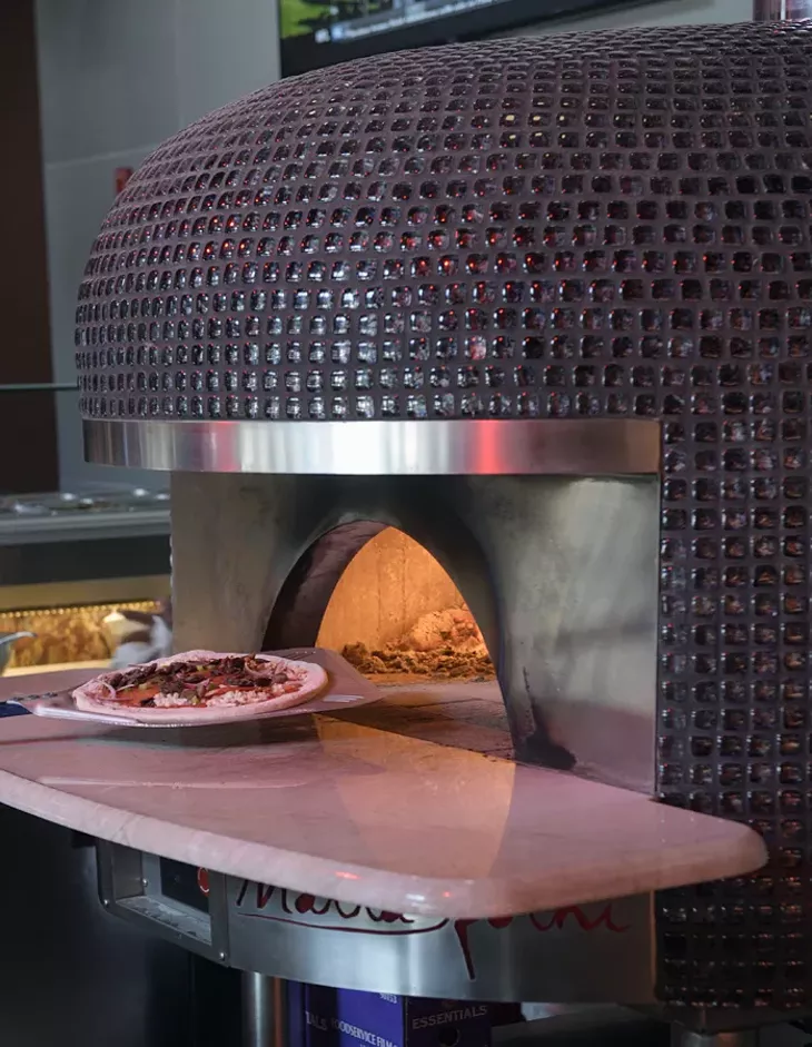 A pizza goes into the custom-built Italian oven at Volare in Norman, Tuesday, Dec. 27, 2016. - GARETT FISBECK