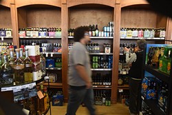 An employee walks past beer selection at Poncho's Liquortown.  mh