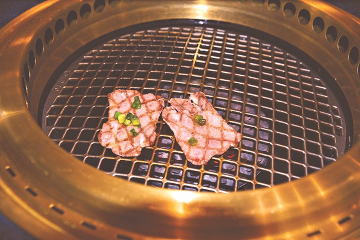 Meats cook on a personal grill imported from Japan. (Photo Jacob Threadgill)