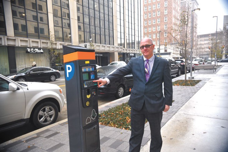 Cory Hubert stands next to a pay-by-plate parking kiosk along Park Avenue downtown. | Photo Laura Eastes