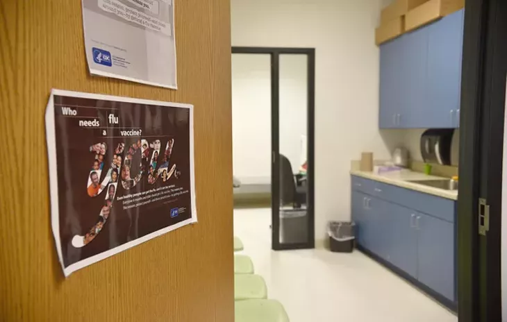 A flyer encouraging the flu vaccine is displayed on the door of the health clinic at Martin Luther King Elementary School in northeast Oklahoma City. (Photo Laura Eastes)