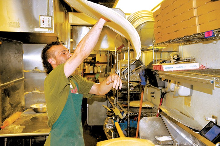 Matt Spivey tosses fresh pizza dough inside Falcone’s Pizzeria. - JACOB THREADGILL