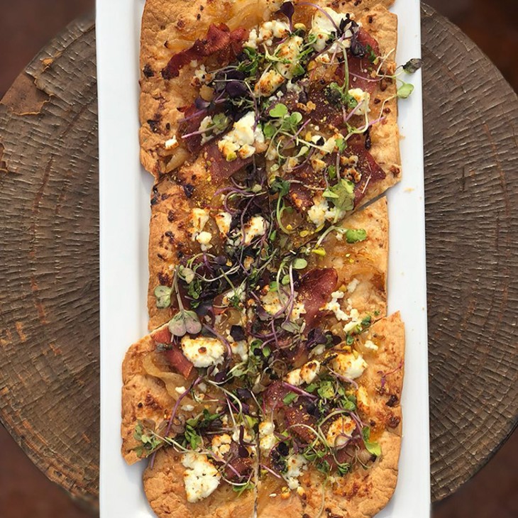 The Hipster flatbread features fig preserve, goat cheese, fresh prosciutto, caramelized onions, pistachios and microgreens. - PROVIDED