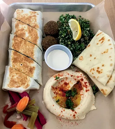 A shawarma wrap with falafel, tabbouleh, hummus, garlic sauce, pita bread and pickled vegetables - JACOB THREADGILL