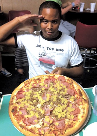 A competitor salutes the camera before attempting the 6-pound Empire Challenge at Papa Angelo’s in Bethany. - PROVIDED