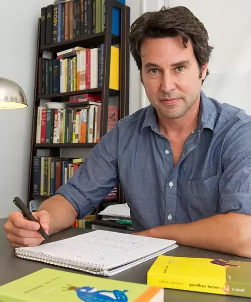 Adam Davies sits at his home desk where he writes longhand as well as on the computer.Photo/Shannon Cornman - SHANNON CORNMAN