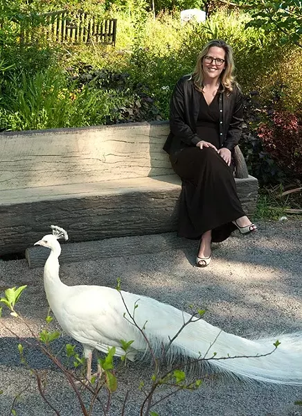 Louisa McCune-Elmore, executive director for the Kirkpatrick Foundation, poses with a peacock in the Children's Petting Zoo at the Oklahoma City Zoo in this 1012 file photo. mh