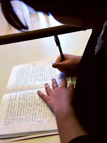 Rhea Brown-Bright, the first named Oklahoma Youth Poet Laureate, works in her notebook recently at the Red Cup coffee shop, located conveniently near Harding Fine Arts Accedemy where she attends high school. mh